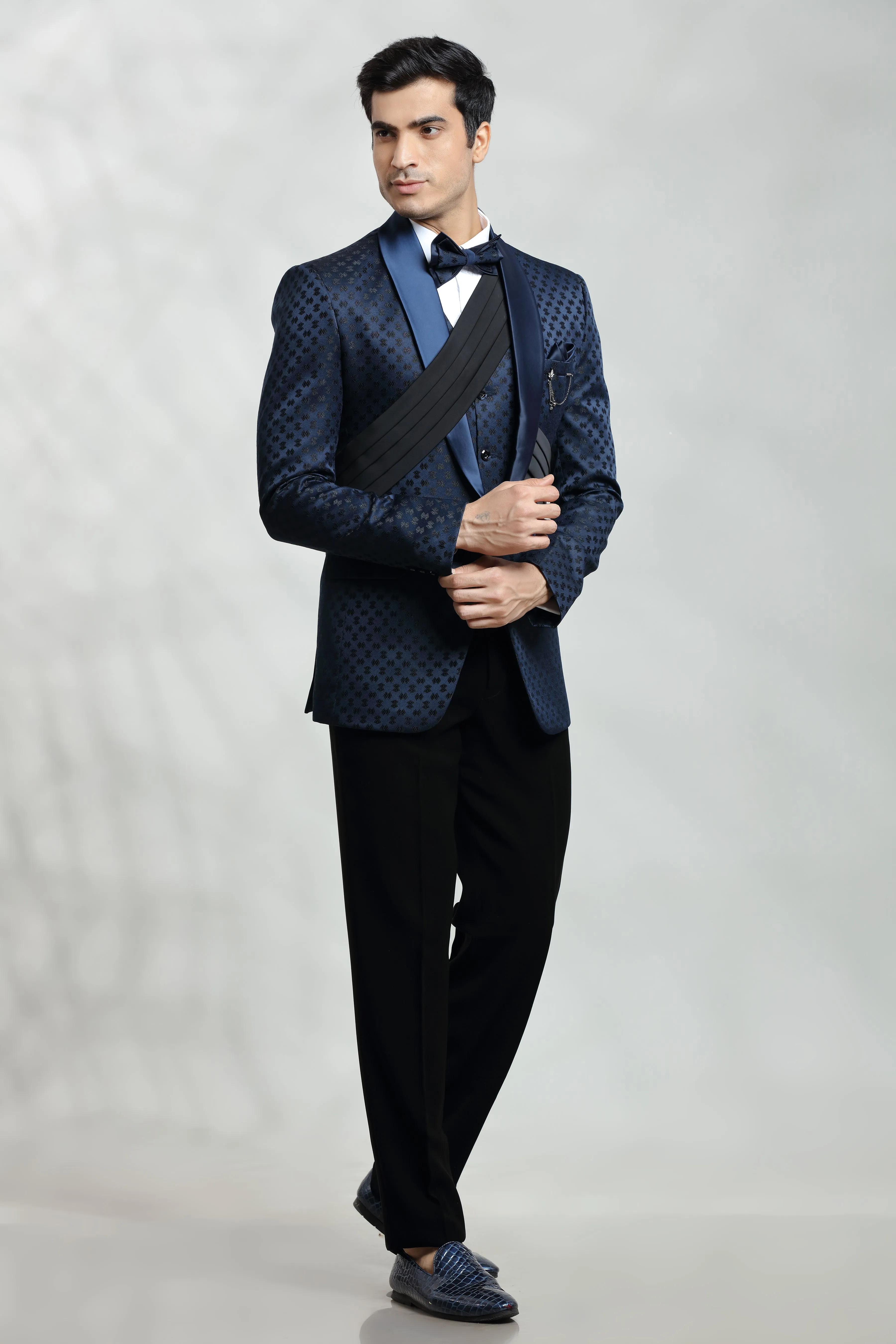 Dark blue self embroidered tuxedo with fabric pleat detail.